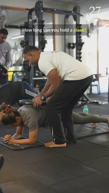 A coach taking a member through floor work at 27 Brick House